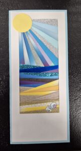folded pieces of paper in blue and yellow made to look like a sunset and beach