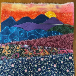 Fabric collage of landscape mountains and a sunset